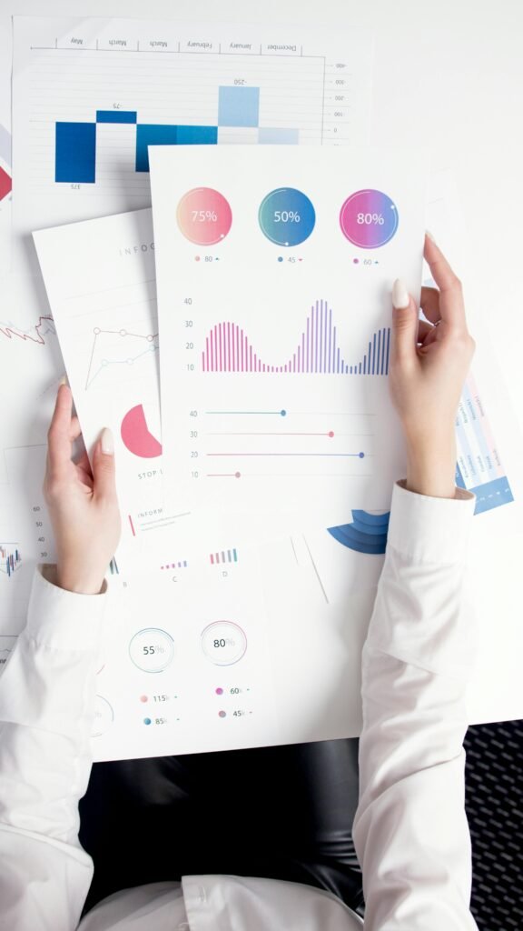pexels-photo-5716034-5716034 Close-up of hands analyzing colorful business data reports in an office setting.