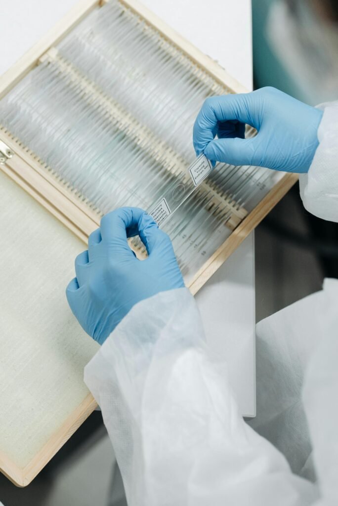 pexels-photo-8442271-8442271 Close-up of a scientist wearing gloves and handling lab slides, ensuring precise research.